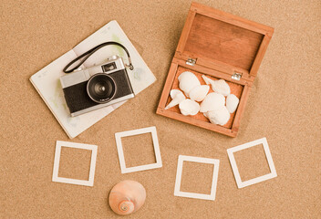 vacation, travel and summer vacation concept: wooden trunk with sea shell and retro photo camera,...