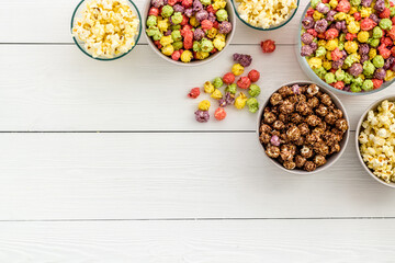 Flavored popcorn on white background top view space for text