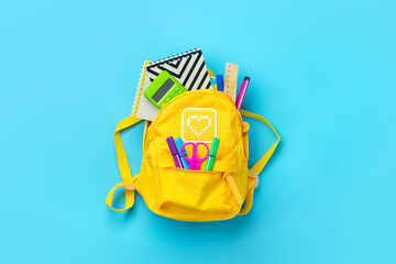 Back to school, education concept. Yellow backpack with school supplies - notebook, pens, ruler,...