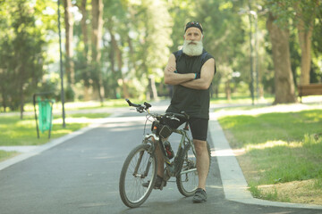 Senior man on cycle ride in countryside. Bearded mature man cycling.
