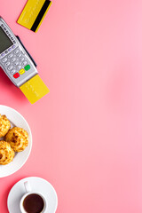 Payment by credit card. Terminal on pink restaurant desk from above copy space