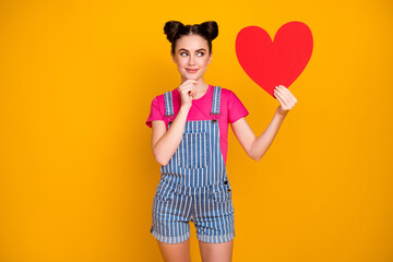 Yes or no Photo of attractive teen lady hold paper heart date invitation postcard minded answer wear magenta t-shirt denim striped overall isolated yellow bright color background