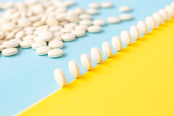 Abstract yellow-blue background,a scattering of pills,pills in a row stand on the edge like...