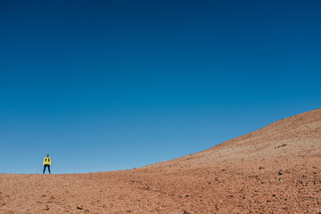 Fototapeta na wymiar Man running in desert trail training marathon in amazing volcano desert landscape