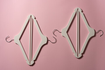 Wooden hangers on pastel pink background