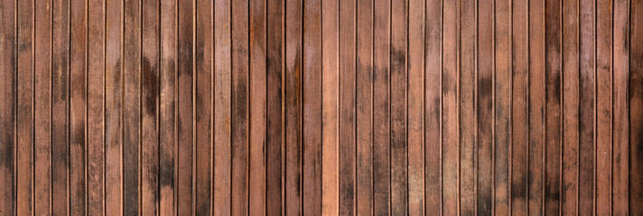 Verwitterte Textur einer braunen Panorama Holzwand aus vertikalen Brettern