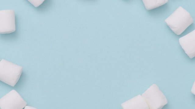 Stop motion animation of sweet and puffy marshmallows on blue