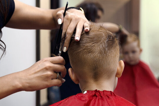 haircut red-haired boy with scissors, hairdresser