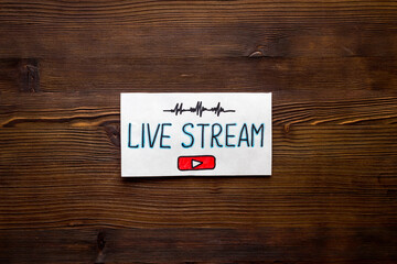 Live streaming concept - words on paper tablet on wooden desk top view