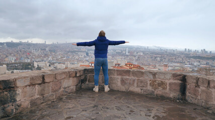 Fototapeta premium A guy with spread arms admires the capital of Turkey, Ankara.