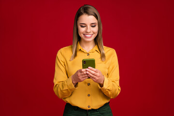 Portrait of her she nice attractive lovely pretty charming focused cheerful cheery girl wearing yellow blouse using device gadget isolated over bright vivid shine vibrant red color background