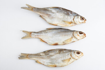 isolated close up top view shot of three Russian dried salted vobla (Caspian Roach) fish on a white background