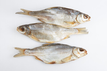 isolated close up top view shot of three Russian dried salted vobla (Caspian Roach) fish on a white background