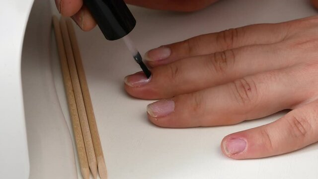 Applying the base of the nail.Drying in a UV lamp with LEDs.