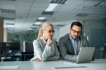 Beautiful business people looking at laptop, portrait.