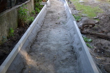the construction of a pedestrian sidewalk begins with the dredging of the road bed and the setting...