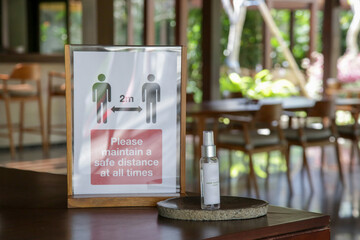 Social distancing sign at the entrance of restaurant as a reminder that everyone needs to comply with new requirements by maintaining a 2 meters distance to protect themselves and others from the Coro
