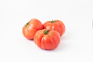 Closeup of pink beef tomatoes on a white background