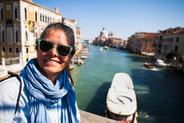 Fototapeta na wymiar A portrait of a very happy American woman touristing in Venice, Italy