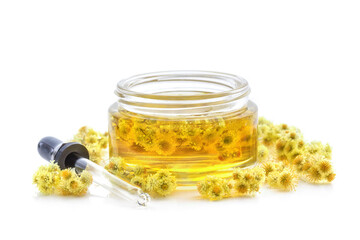 Immortelle essential oil with dried flowers of Helichrysum. Medicinal plant, skincare, anti-aging. Isolated on white background
