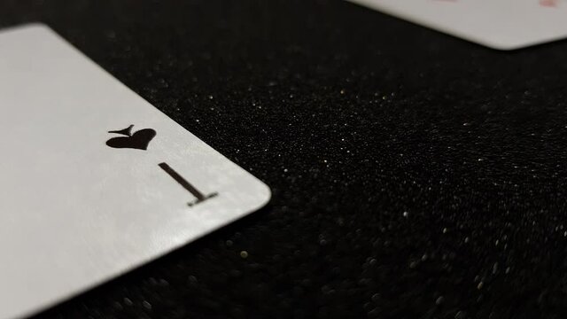 Macro view of ace of spades and others falling on a black table