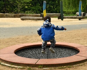 Fototapeta premium Auf einem Kinderspielplatz - Spielen, Hüpfen, Spaß haben.