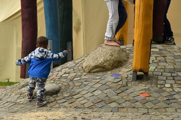Auf dem Spielplatz. Bergauf - Junge versucht zu den anderen Kindern zu gelangen