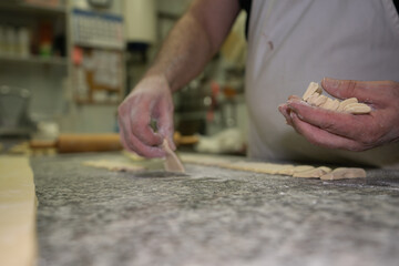 baker ordering the dough into triangles and then making the croissants in a bakery