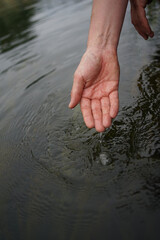  Hands dipping in river water    