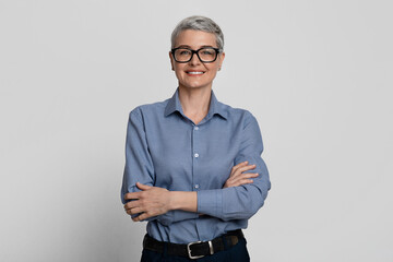 Portrait Of Attractive Mature Businesswoman In Stylish Eyeglasses Posing With Folded Arms