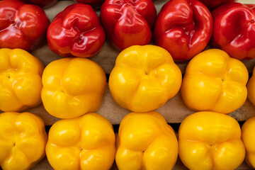 Close up of fresh peppers yellow and red lying on shelf in supermarket. Market and trade concept