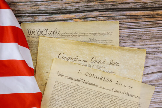 Close Up Of A Replica Of U.S. Document Of American Constitution We The People With USA Flag.