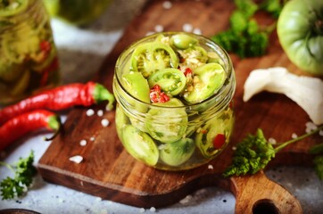 Fermented Pickled green tomatoes with horseradish and hot pepper on a gray background