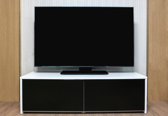 a black cabinet decoration and a large display TV set in the living room.
