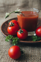 Fresh tomato juice on a background of red ripe tomatoes/tomatoes
