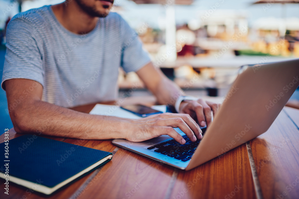 Poster cropped image of skilled male it developer typing code on modern laptop working on freelance, profes