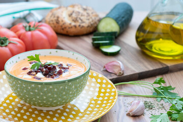 Bowl with salmorejo and its ingredients. Typical Spanish food. Close up. Focus on the bowl