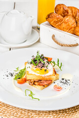 Sandwich with vegetables and an egg on a white round plate
