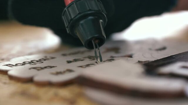 Close-up of the hand of a craftsman making a souvenir from wood using burning painting. DIY souvenirs at home. selective focus, shallow depth of field
