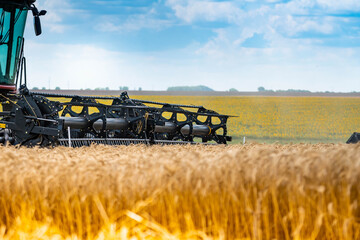 Combine mower for harvesting wheat. Farm work in the yellow field.