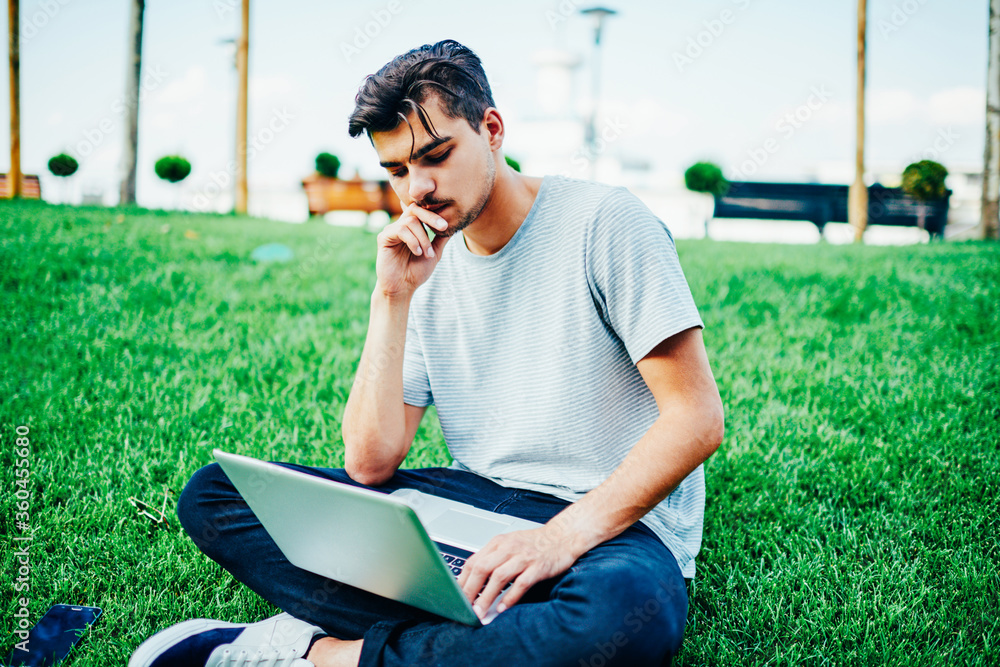 Poster concentrated skilled student reading information from websites on netbook connected to 4g internet o