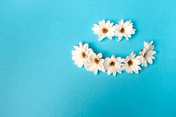 Smiley lined with daisies on a blue background