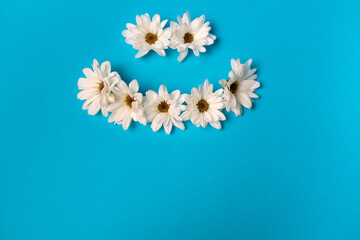 Smiley lined with daisies on a blue background