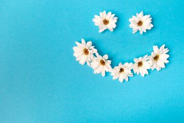 Smiley lined with daisies on a blue background