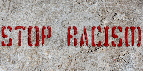Stencil stop racism on an old concrete wall. Background. Collage. Concept.