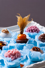 .Various types of gourmet brigadeiro on a mirrored tray. Typical sweet from Brazil with condensed milk and chocolate. .Highlight for physalis