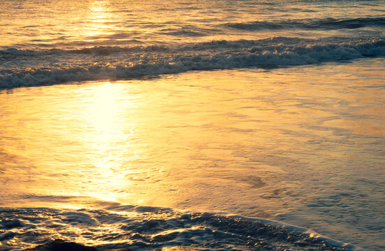 Shocking sun drop with vibrant colors. Golden water at sunset. Vacation landscape in the tropics.