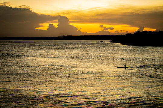 Shocking sun drop with vibrant colors. Golden clouds at sunset. Vacation landscape in the tropics.