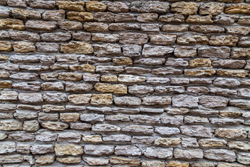 Stone wall texture background of stones stick together with clay.