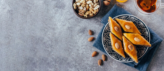 Baklava. Ramadan Dessert. Traditional Arabic dessert with nuts and honey, cup of tea on a concrete table